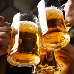 Trzy kufle złocistego piwa w dłoniach. Zastanawiasz się, ile piwo ma kalori?