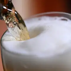 Piwo nalewane do szklanki. Czy piwo pomaga na kamienie nerkowe? Piana tworzy się na powierzchni.