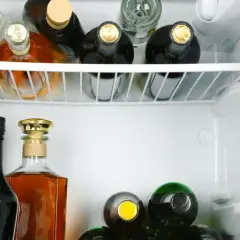 Wódka otwarta w lodówce może stać długo, ale jej smak się zmienia. Widać tu różne butelki alkoholu.
