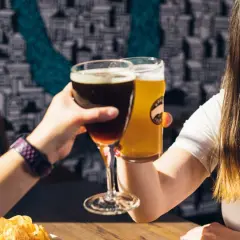 Dwie kobiety wznoszą toast piwem. Jedno ciemne, drugie jasne. Czy to kwarta piwa?