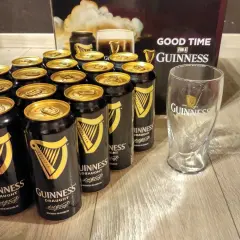 Dużo puszek piwa Guinness i szklanka, gotowe na dobrą zabawę.