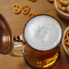 Piana na piwie w kuflu, obok miseczki z precelkami. Zastanawiasz się, ile kcal ma piwo?
