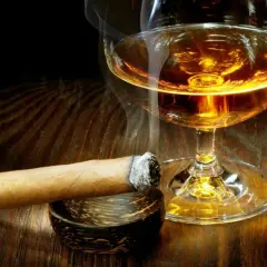 Dymiące cygaro i kieliszek bursztynowego trunku. Czy whisky podnosi cukier? To pytanie zadaje sobie wielu, delektując się tym zestawieniem.