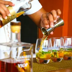 Barman nalewa rum VSOP do szklanek. Czysta wódka ma zazwyczaj 40% alkoholu, ale ten rum jest wyjątkowy.