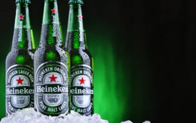 Trzy butelki Heineken, holenderskiej marki piwa, w lodzie.