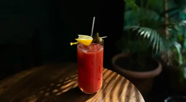 Kieliszek Bloody Mary z cytryną i oliwką. Ciekawa bloody mary historia tego drinka zaczyna się w latach 20. XX wieku.