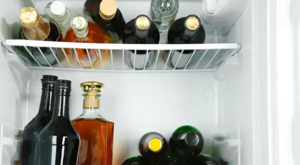 Wódka otwarta w lodówce może stać długo, ale jej smak się zmienia. Widać tu różne butelki alkoholu.