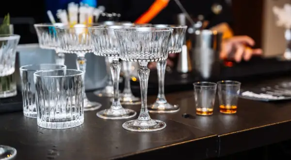 Eleganckie kieliszki i szklanki czekają na gości weselnych przy samoobsługowym drink barze. Idealne miejsce na drinki z przepisami.
