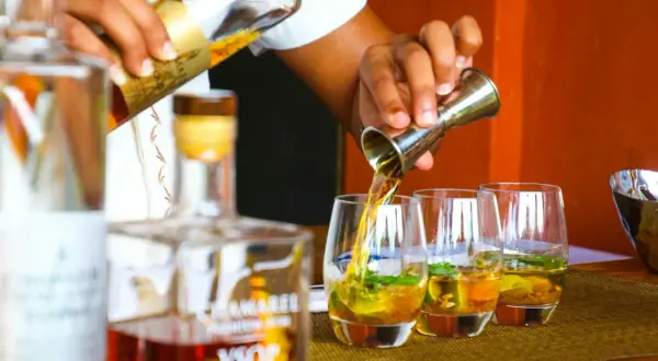 Barman nalewa rum VSOP do szklanek. Czysta wódka ma zazwyczaj 40% alkoholu, ale ten rum jest wyjątkowy.