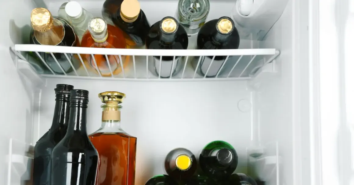 Wódka otwarta w lodówce może stać długo, ale jej smak się zmienia. Widać tu różne butelki alkoholu.